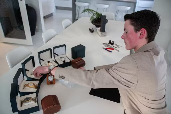 The founder examining wristwatches at a table